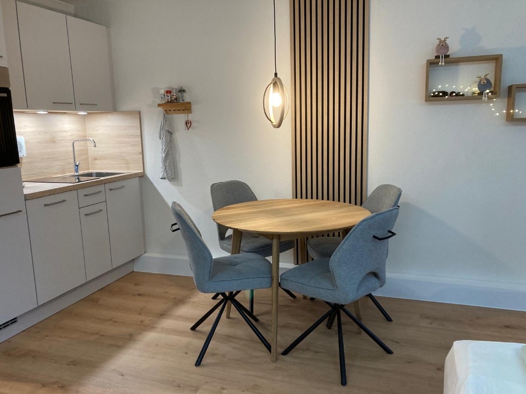 Ferienwohnung in Sankt Englmar: heller Essbereich mit rundem Holztisch und Blick in die Küche